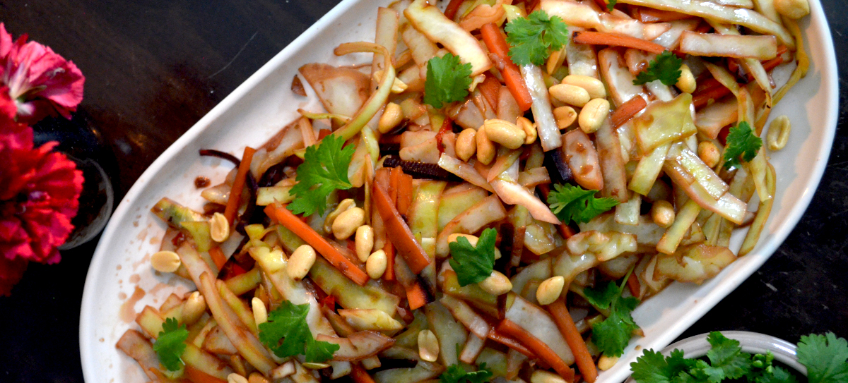 Wokattuja kasviksia valkoisessa tarjoiluastiassa.